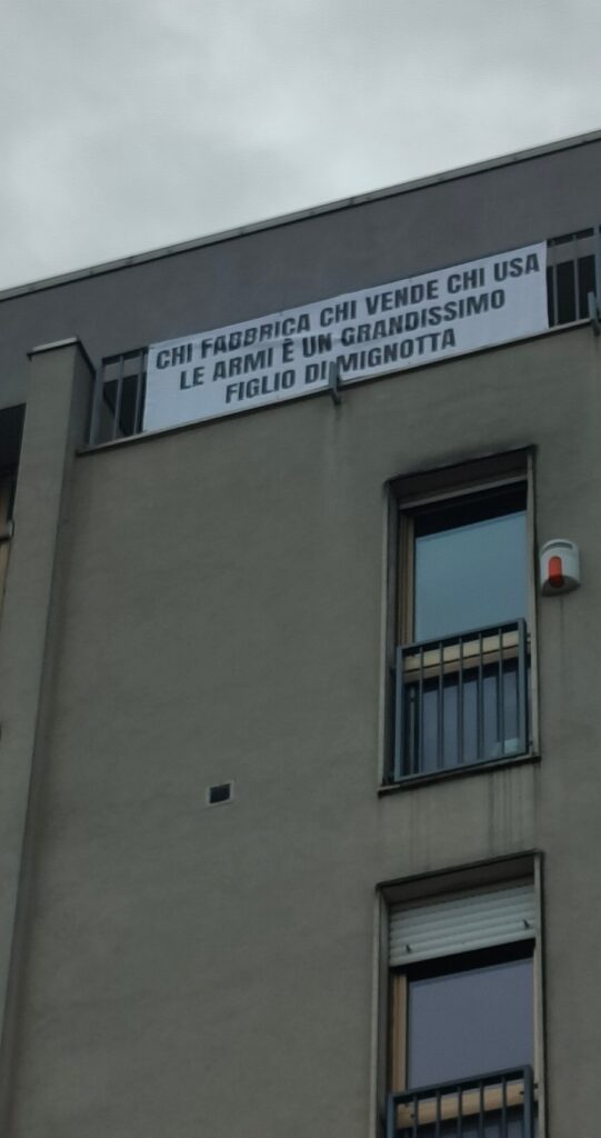 "chi fabbrica, chi vende, chi usa le armi è un grandissimo figlio di mignotta" (Ugo Pierri, Trieste, 2026) - striscione all'ultimo piano di via del Veltro 59